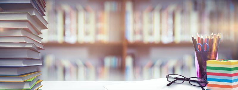 学生课桌上的书籍和眼镜等文具