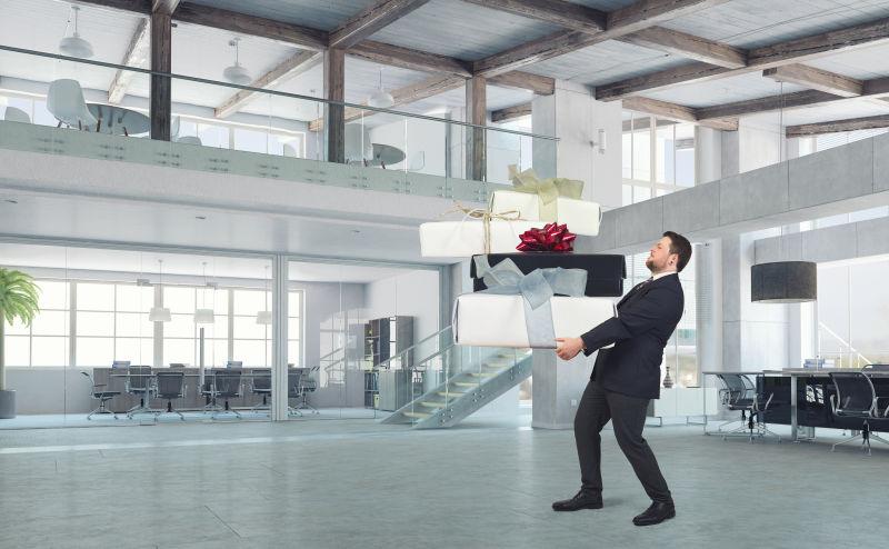 年轻的商人手里拿着大礼盒