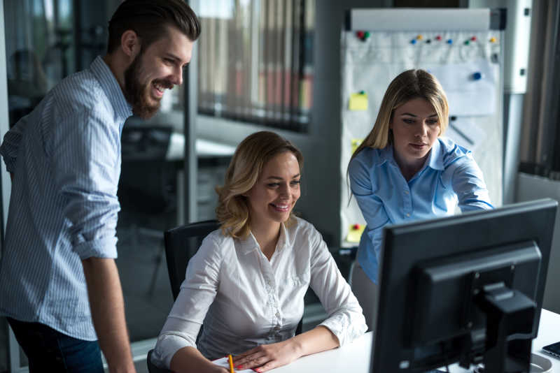 办公桌前的两个美女和一个帅哥