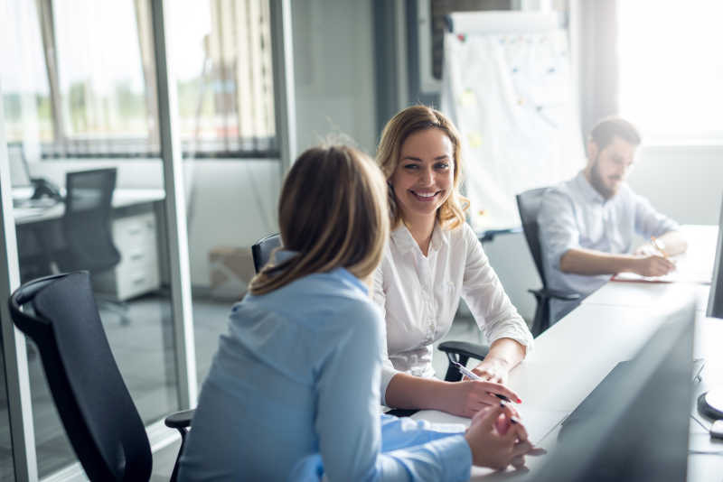 帅气男人旁边两个美女在聊天