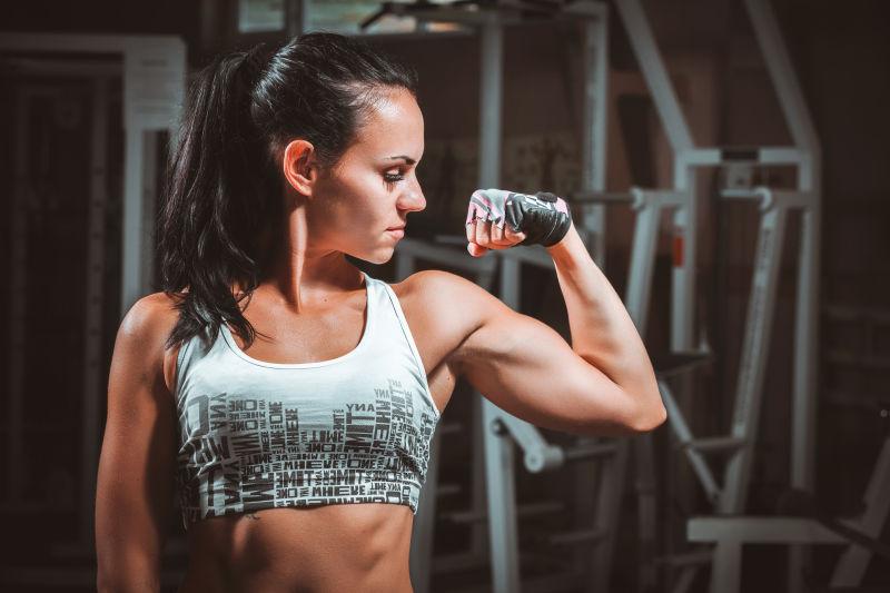 在健身房晒肱二头肌的年轻美女