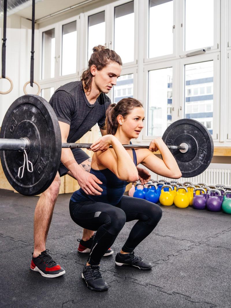 健身教练指导女子的哑铃健身项目