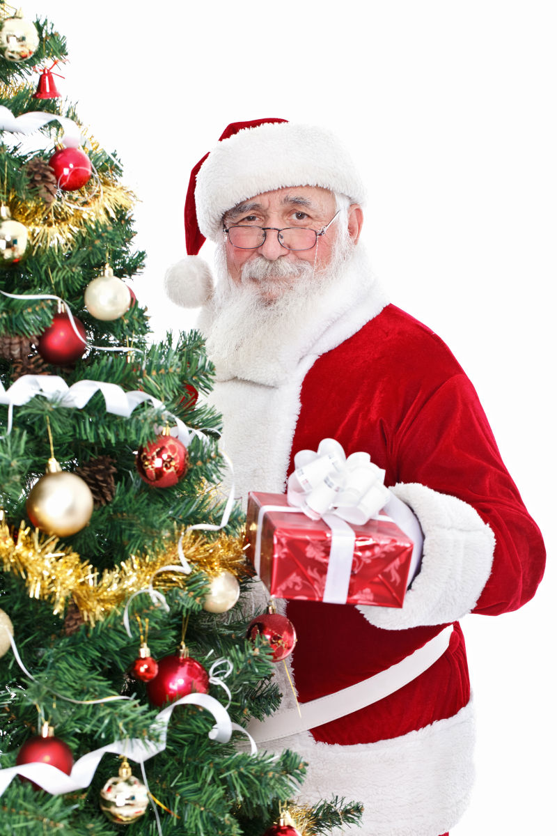 圣诞老人把礼物盒放在圣诞树下