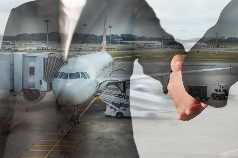 握手的商人和机场背景的双重曝光