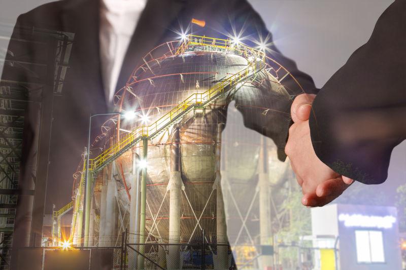 握手的商人与能源厂的双重曝光