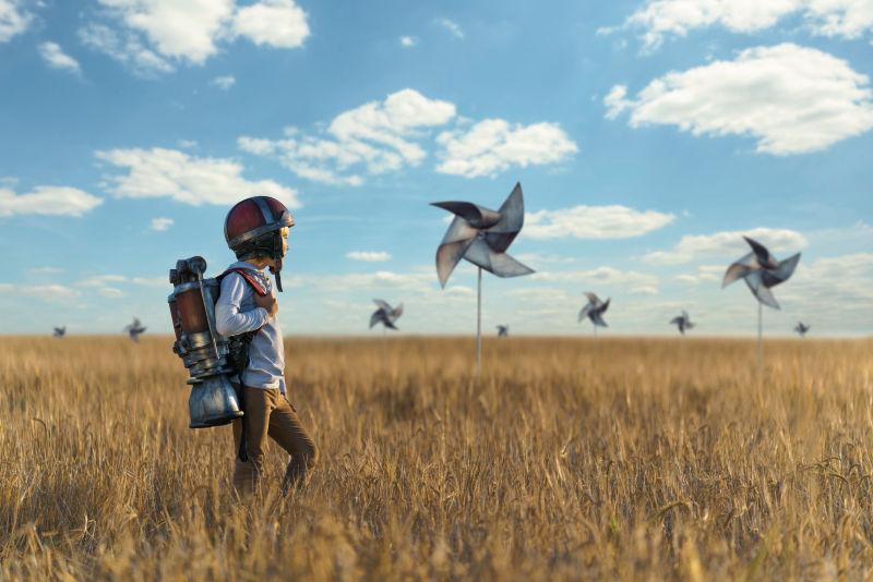 在风车田野里背着喷气式飞行器的男孩