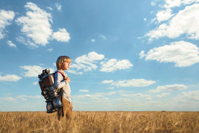蓝天下背着喷气式飞行器的小男孩